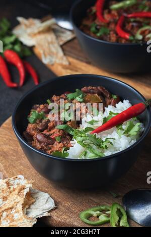 Scharfe Chili con Carne mit Hackfleisch, Gemüse, Reis. Mit Chilischote garniert. Mexikanisches Essen lecker und würzig. Stockfoto