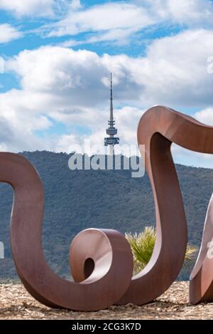 Der Telstra Tower auf dem Black Mountain wird von einem Teil der Wide Brown Land Skulptur im National Arboretum in Canberra, Australian Capital Territory, eingerahmt Stockfoto