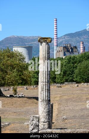 Säulen aus den Ruinen des antiken Megalopolis mit dem Kühlturm und dem Kamin des modernen Kraftwerks von Mergalopoli im Hintergrund. Central Pelo Stockfoto