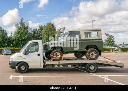 Land Rover Defender auf der Rückseite des Citroen Relay Bergungslagers. Stockfoto