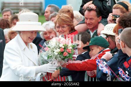 Die Königin erhält Blumen, als sie Gleasons Works Ltd. Verlässt, während einer Tour durch Plymouth. Stockfoto