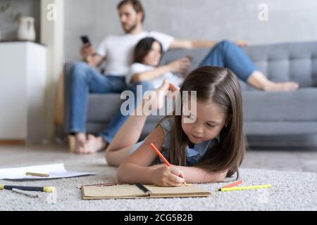Nettes Kind Mädchen spielen auf dem Boden, Vorschule kleines Mädchen Zeichnung mit Buntstiften auf Papier verbringen Zeit mit der Familie Stockfoto