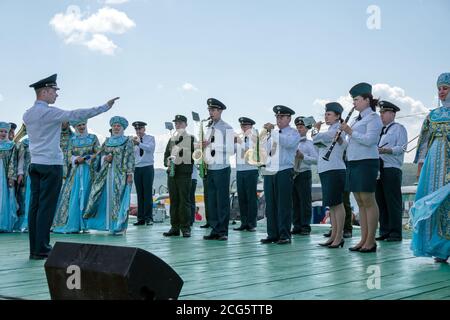 Eine Blaskapelle des Innenministeriums und ein Ensemble in russischen Volkstrachten treten auf der Promenade auf, beim Karatag Musikfestival. Kra Stockfoto