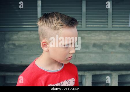 Porträt von traurigen und enttäuscht blauäugigen blonden Jungen. Er sieht mürrisch aus mit wütender Gesichtsausdruck. Emotionaler Gesichtsausdruck. Depressive Stimmung. Stockfoto