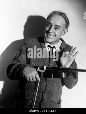 Schauspieler Alec Guinness verkleidete sich als seine Figur "Professor Marcus aus dem Film "The Lady Killers". ER wurde mit dem CBE (Commander of the Order of the British Empire) in der Queen's Birthday Honors ausgezeichnet. Stockfoto