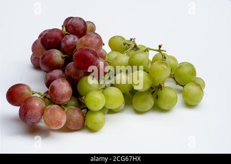 Weiß und Rot Seedless essende Trauben auf weißem Hintergrund frisch gewaschen, Vegan Stockfoto