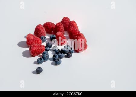 Frisch gepflückte und gewaschene Heidelbeeren und Himbeeren zum Veganen Frühstück Stockfoto