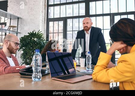 Geschossen von einer Gruppe junger Geschäftsleute in einer Sitzung. Vielfältige Gruppe von jungen Designern lächelnd während einer Besprechung im Büro. Stockfoto
