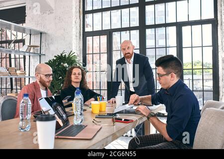 Geschossen von einer Gruppe junger Geschäftsleute in einer Sitzung. Vielfältige Gruppe von jungen Designern lächelnd während einer Besprechung im Büro. Stockfoto