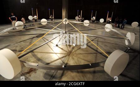 Eine allgemeine Ansicht der Jon Fawcett-Installation "EIR", sechs Kabinen, die von Psychikern bemannt sind, die Mitglieder der Öffentlichkeit für eine mögliche Rekrutierung bei einer geheimen Organisation abschirmten, und Whum, ein 7 Meter breites, langsam drehendes Rad mit neun zylindrischen Gefäßen, die nicht offengelegte Materialien auf seinem Rand enthalten, umgeben von zehn weiteren, Das ist Teil der Undercurrent: Young People's Ausstellung in der Tate Modern, London. Stockfoto