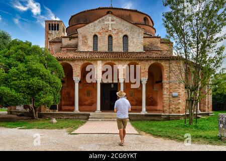 Mann, der vor der Kirche Santa Fosca, Torcello, Venedig, Venetien, Italien steht Stockfoto