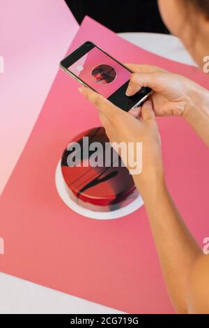 Frau fotografiert einen roten Samtkuchen Stockfoto