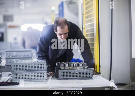 Ingenieur, der Maschinenteile in einem Industriewerk inspiziert, Deutschland Stockfoto