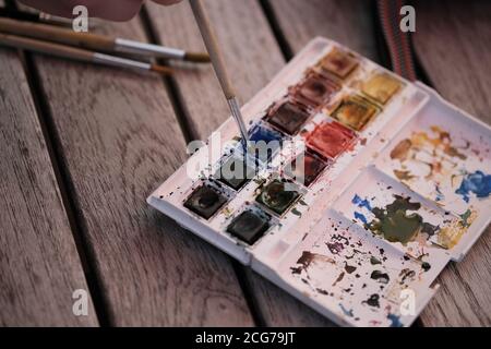 Aquarellfarben und Pinsel auf einem Holztisch Stockfoto