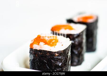 Nahaufnahme von drei Sake-Maki-Rollen auf einem Teller Stockfoto