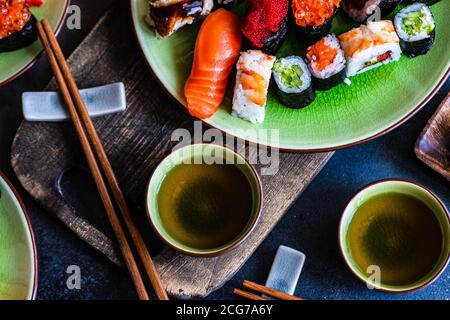 Teller mit verschiedenen Maki-Sushi-Rollen und Nigiri-Sushi Eine Tabelle Stockfoto