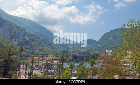 Top Luftbild mit Blick auf die Boka Bucht und Palmenpromenade mit Touristen, Autos und Boote im Herzen der Stadt Kotor in Montenegro an einem sonnigen Tag Stockfoto