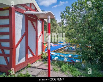 Blick über alte Bootstation mit Pontonschwimmer Kai mit Soviet Times Tretboote und Tretboote im Park See an einem sonnigen Tag. Stockfoto