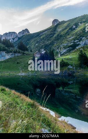 Die Berghütte und die Alpsteinkette reflektieren sich Der Faelensee im Schweizer Kanton Appenzell sonnenaufgang Stockfoto