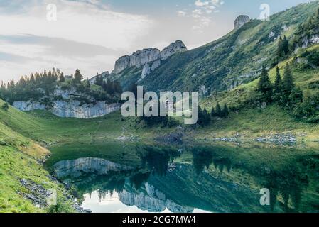 Die Berghütte und die Alpsteinkette reflektieren sich Der Faelensee im Schweizer Kanton Appenzell sonnenaufgang Stockfoto