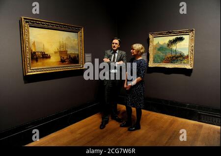 Nicola Kalinsky Direktor des Barber Institute of Fine Art, Birmingham, und Nicholas Penny der Direktor der Nationalgalerie stehen zwischen der Kirche in Varengeville von Claude Monet (rechts) und der Sonnenaufgang durch Dampf von JMW Turner (links), im Rahmen der Geburt einer Sammlung: Meisterwerke des Barber Institute of Fine Arts, das vom 22. Mai bis 1. September in der National Gallery, London stattfindet. Stockfoto