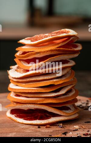 Nahaufnahme von getrockneten Grapefruitscheiben nach der Austrocknung auf Holzbrett gestapelt, gesundes Snack-Konzept Stockfoto