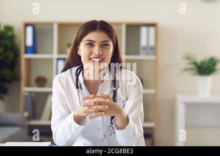 Lächelnde Frau Arzt Therapeut Blick auf Kamera in der medizinischen Klinik Büro oder während der Online-Beratung Stockfoto