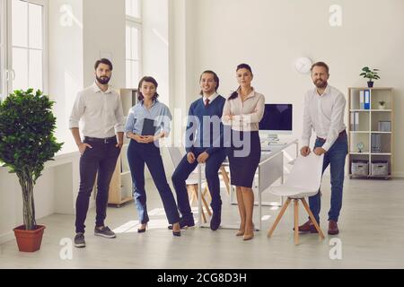 Gruppe von jungen Profis stehen in modernen Büro bereit für Firmenmeeting Stockfoto