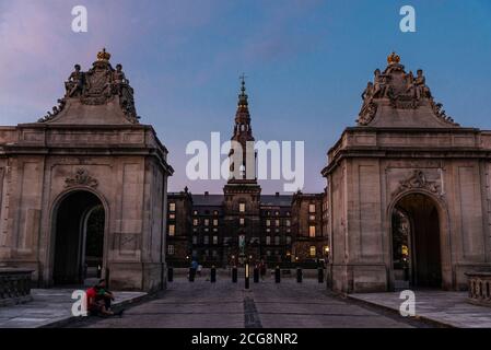 Kopenhagen, Dänemark - 26. August 2019: Fassade des Christiansborg Palastes, Regierungsgebäude auf der Insel Slotsholmen, bei Sonnenuntergang mit Menschen aro Stockfoto