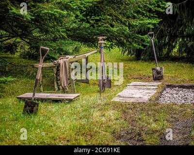 Pik steht im Boden in der Nähe eines neu gefüllten Lochs. In einem britischen Garten. Stockfoto