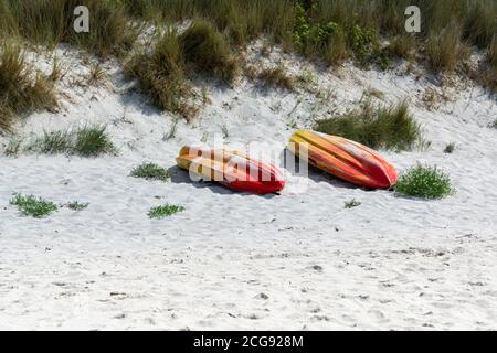 Zwei farbenfrohe Kajaks auf dem Meer an einem Sandstrand in der St. Martin's Isles of Scilly Stockfoto