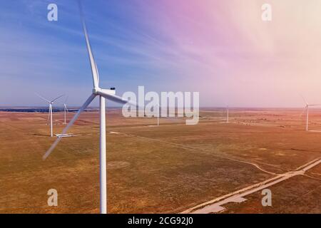 Windturbinen produzieren alternative grüne Energie gegen den blauen Himmel Stockfoto