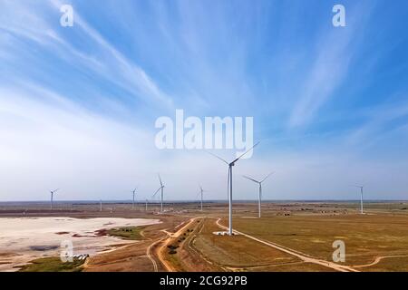 Windturbinen produzieren alternative grüne Energie gegen den blauen Himmel Stockfoto