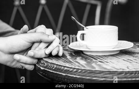 Weibliche und männliche Hände halten Tasse Kaffee. Paar in der Liebe hält Hände mit Kaffee. Paar hält Hände, eine Tasse heißen Kaffee Stockfoto