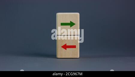 Konzeptuelles Bild der Wahl und Richtung. Holzwürfel mit Pfeilen in entgegengesetzte Richtungen. Schöner grauer Hintergrund, Kopierbereich. Stockfoto