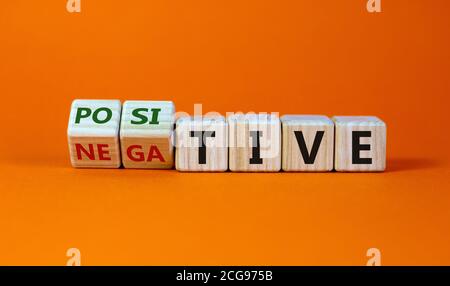 Würfel gedreht und den Ausdruck 'positiv' in 'negativ' geändert. Schöner orangefarbener Hintergrund. Medizinisches Konzept. Speicherplatz kopieren. Stockfoto