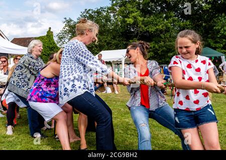 Weibchen nehmen an EINEM Tauziehen des Krieges Teil, Fairwarp Fete, Fairwarp Village, East Sussex, Großbritannien. Stockfoto