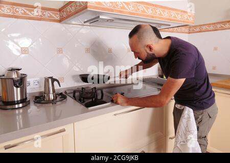 Junger hispanic autarke Mann im Begriff zu kochen Stockfoto