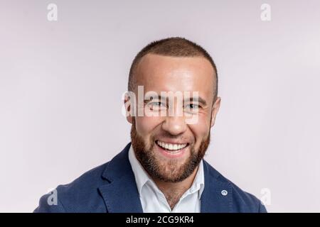 Bärtig fröhlich Chief man in Business Anzug, mit einer guten Stimmung nach erfolgreichem Deal. Kopf- und Schulterportrait des Führers der Firma isoliert auf g Stockfoto