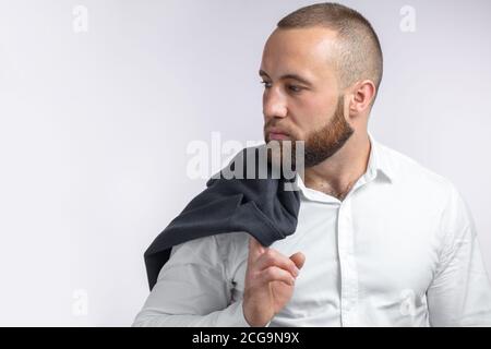 Mann bärtigen Mann in edlen Kleidern hält seine Jacke über Schulter auf weißem Hintergrund Stockfoto