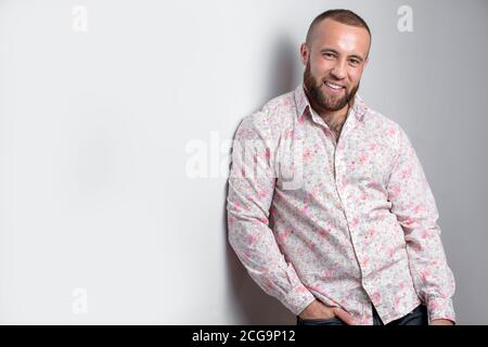 Stilvoll gekleidet mannhaft Designer oder männliche Modell des europäischen Aussehen, trägt dunklen Bart Blick auf die Kamera mit positiven und zufriedenen Gesicht zum Ausdruck bringen Stockfoto