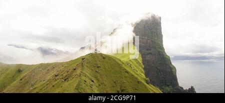 Kallur Leuchtturm auf der Insel Kalsoy in einer grünen Graslandschaft auf den Färöern, Dänemark. Stockfoto