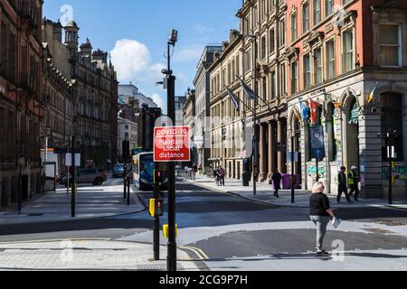 Ein rotes Straßenschild, das die Menschen daran erinnert, die soziale Distanz aufrecht zu erhalten, das im September 2020 während der Covid19-Pandemie in Liverpool, England, zu sehen war. Stockfoto