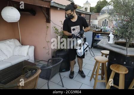 Istanbul, Türkei. September 2020. Ein Kellner mit Gesichtsmaske desinfiziert am 8. September 2020 eine Bar in Istanbul, Türkei. Die Bars und Nachtclubs in der Nachbarschaft sind in der Regel von jungen Istanbuliten überflutet, während Musik und Unterhaltung bis zum ersten Licht des Morgens fortgesetzt werden. Früher am Dienstag jedoch, das Innenministerium angekündigt, dass alle Arten von Musik in Restaurants, Cafés und Bars im ganzen Land nach Mitternacht verboten wurden, um die Ausbreitung der COVID-19 Pandemie einzudämmen. Quelle: Osman Orsal/Xinhua/Alamy Live News Stockfoto