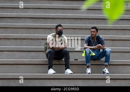 Zwei junge Männer sitzen auf der Stadttreppe Boston, Massachusetts, USA Stockfoto