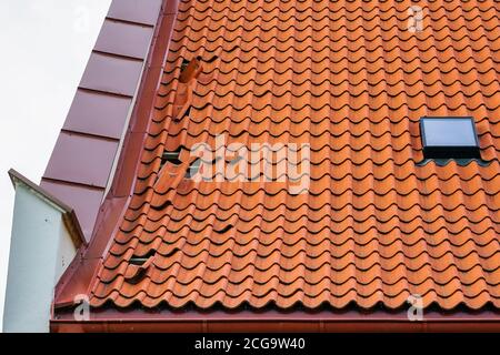 Dachschaden aus Tonziegel, einige umgestürzte Fliesen Stockfoto