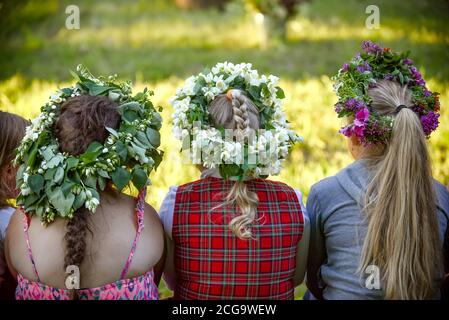 Eine Rückansicht der Frauen, die traditionelle Blumenhedressen für das Mittsommerfest von Ligo in Lettland tragen Stockfoto