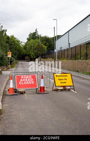 Straßenschilder auf der Straße nach Elland, West Yorkshire, die darauf hinweisen, dass die Straße vor dem Hotel für den Verkehr gesperrt ist, aber Geschäfte wie üblich geöffnet sind Stockfoto