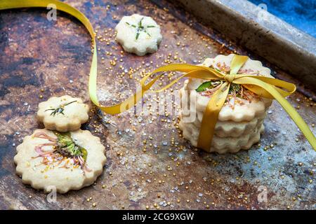 Kleiner Stapel Shortbread-Kekse mit Fliege, essbaren Blumen und Goldzucker, Hochwinkelansicht Stockfoto