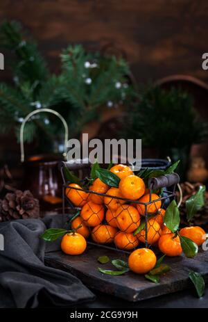 Frische reife Mandarinen mit Blättern auf Holztisch Stockfoto